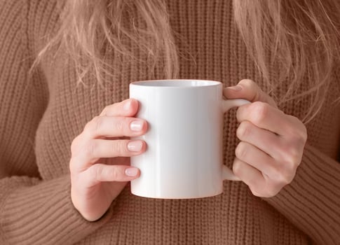 woman hands holding white mug mockup, trendy colored brown sweater photo