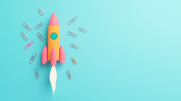 Creative Flat Lay of Rocket Made of Office Supplies with Paperclips on Vibrant Blue Background, Symbolizing Innovation and Creative Concept, Ideal for Business and Education Themes photo