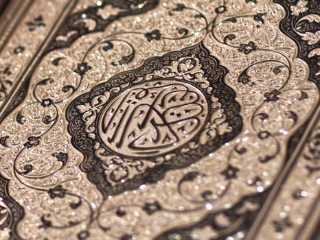 Islamic Book Quran with golden arabic calligraphy that means Al-Quran photo