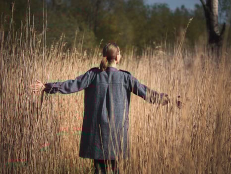 Happy young girl enjoying the beauty of a sunny autumn day in tall grass photo