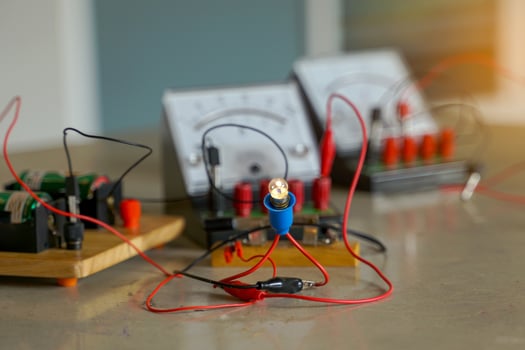 the light bulb when connected to an electrical circuit in series and a set of equipment connected to the electrical circuit, including a voltmeter, ammeter, wires and electrical bridge. photo