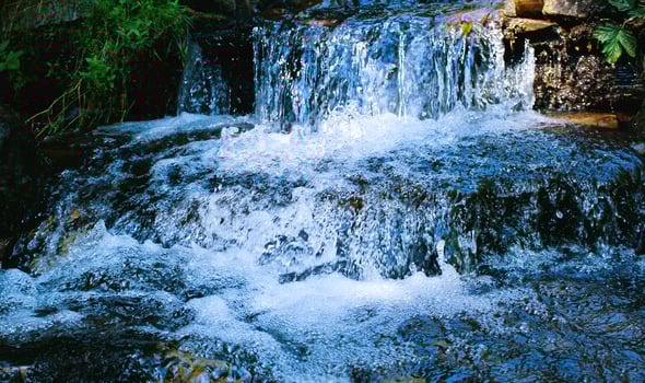 Pure mountain water foams in the streams of a small stepped waterfall photo