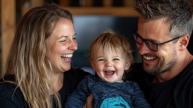 A man and woman with a baby laughing photo