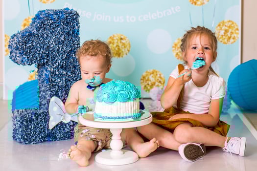 boy playing with a cake during cake smash birthday party photo