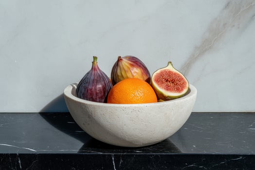 Figs and orange in a minimalist bowl on a marble surface photo