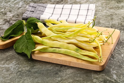 A cutting board with beans and leaves photo