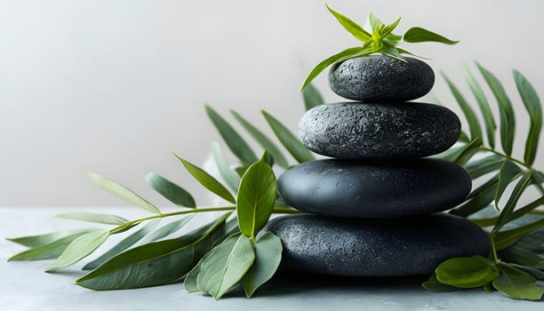 A stack of black stones with green leaves photo