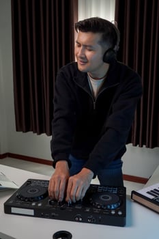 Asian DJ is happily playing music at home. Practice concept of playing music at home. photo