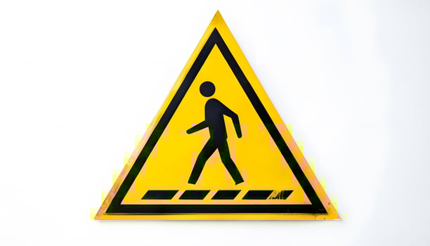A yellow warning sign with a black man walking across it photo