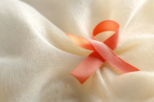 Close-up of an red awareness ribbon on asoft beige fabric background photo