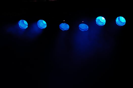 Blue spotlights and smoke on black background photo