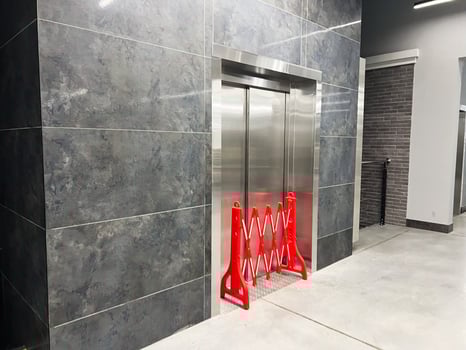 Modern Elevator Area With Closed Doors and Red Safety Barrier photo