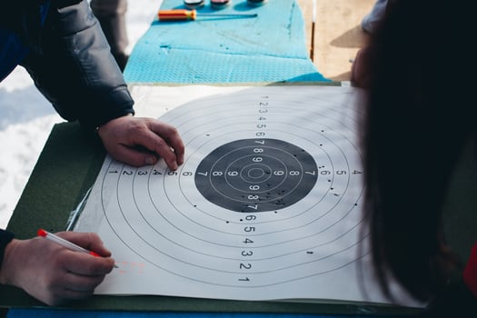 A person is pointing to a target on a paper photo