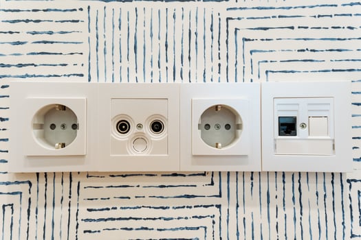 Three white electrical outlets on the wall enhance the rooms functionality by providing essential power access for electronic devices, promoting convenience for all users photo