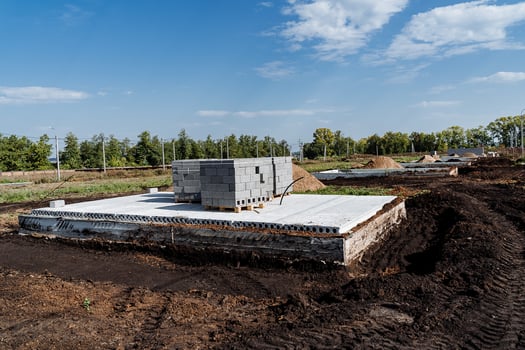 A concrete foundation is being built in a field photo