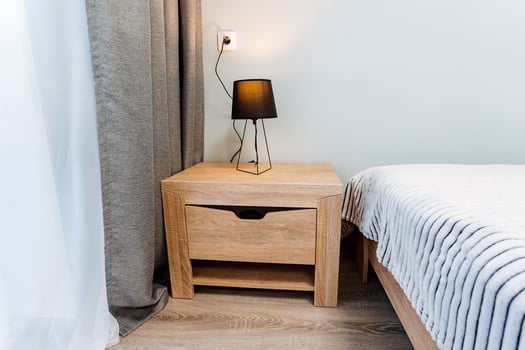 Cozy interior design with furniture, wood flooring, and comforting lighting in a rectangular bedroom of a property. photo