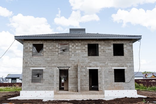 A sturdy brick house is currently being constructed in a rural area photo