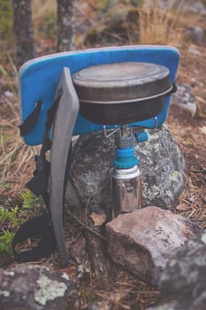 A blue and gray backpack sitting on a rock photo