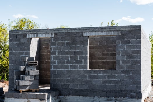 A brick building under construction against a cloudy sky photo