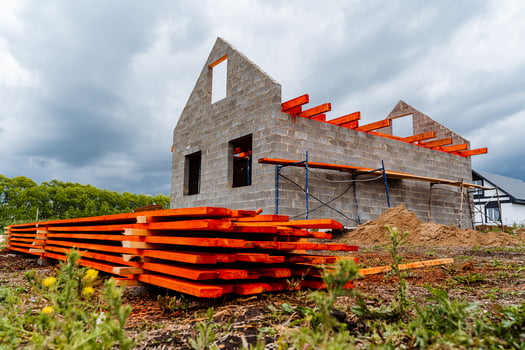A house under construction with orange and black wood photo