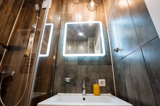 This contemporary bathroom showcases a chic sink, a beautifully designed mirror, and a revitalizing shower space, making it an ideal retreat for relaxation after a tiring day at work photo