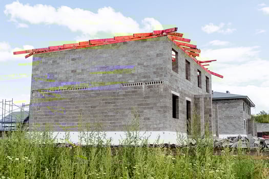 A new house is currently under construction, which is utilizing highquality bricks and sturdy wooden beams for strong support, based on the detailed building plan that has been provided photo