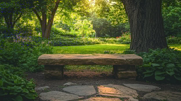 A stone bench sitting in a park surrounded by trees photo