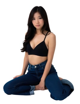 A woman in jeans and a black bra top sitting on the floor photo
