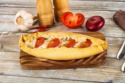 A bread roll with tomatoes and garlic on it photo