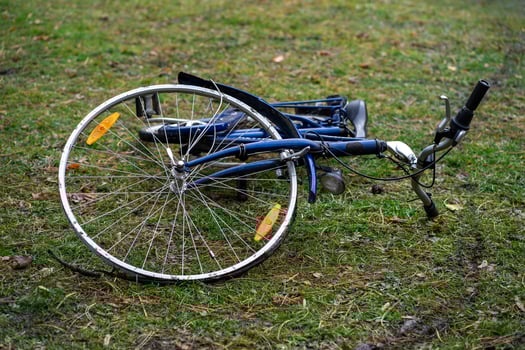View of a blue broken bicycle lying on green grass. photo