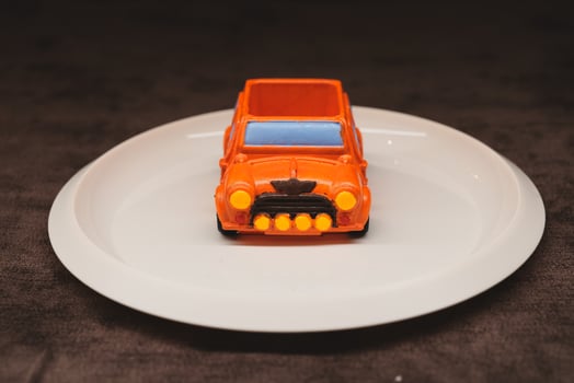 An orange toy car placed beautifully on a plate is a vibrant and playful decorative piece photo