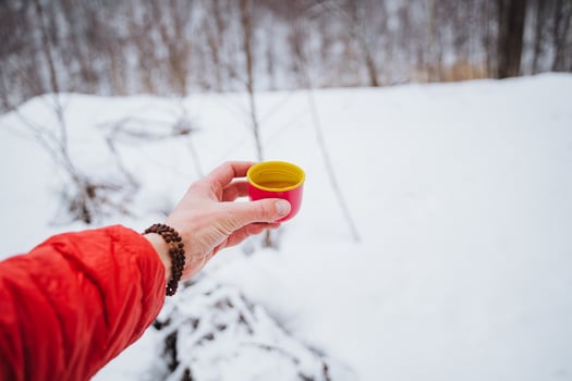 A person holding a cup of coffee in the snow photo