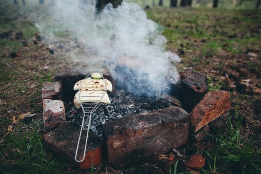 A grill with a hot dog on it sitting on top of a fire photo
