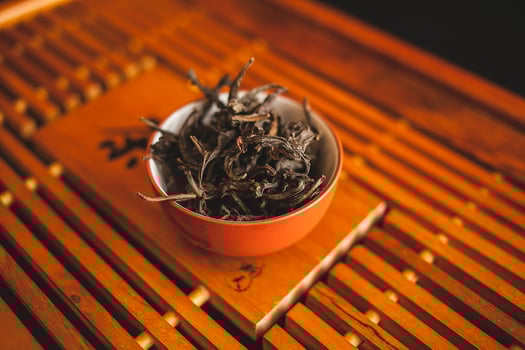 A bowl of tea sitting on top of a wooden table photo