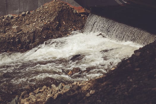 A water pipe is flowing over rocks photo