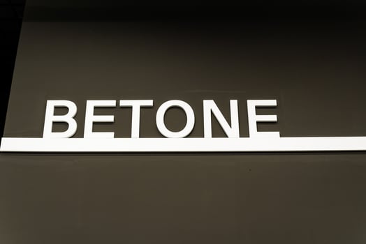 The white word betone stands out boldly against the brown background, becoming a prominent focal point in the design composition, captivating attention with its visual impact photo