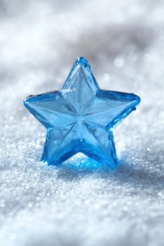 A blue star shaped crystal on a snow covered surface photo