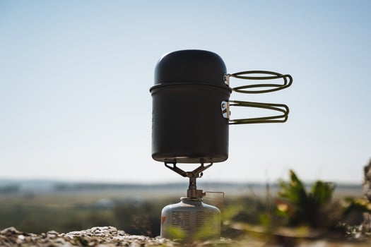 This is a versatile portable camping stove set against a beautiful outdoor scenic backdrop, perfect for all your adventures in nature photo