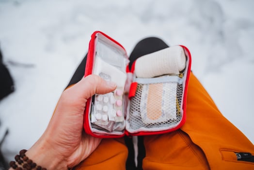 A person holding a cell phone and a first aid kit photo