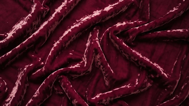 Rich Deep Red Velvet Fabric with Elegant Soft Texture and Crumpled Pattern on Dark Background photo