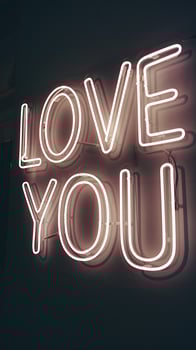 Bright Neon Love You Sign Glowing in Pink on Dark Background for Romantic Occasions and Decor photo