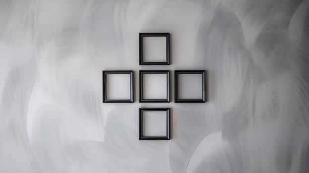 Minimalist Black Square Frames Arranged in Geometric Pattern on Neutral Gray Textured Wall Background photo