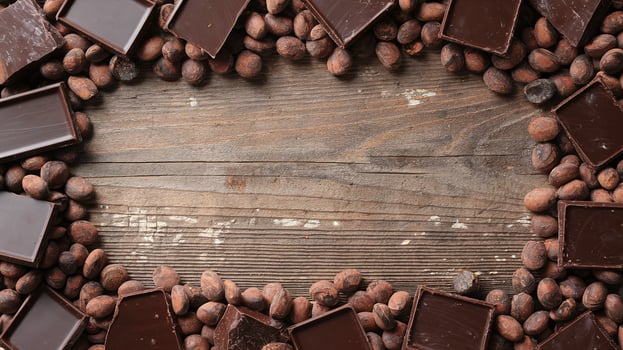 Top View Arrangement of Dark Chocolate Bars and Cocoa Beans on Rustic Wood Background photo