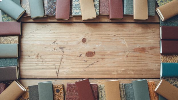 Flat Lay of Colorful Hardcover Notebooks with Patterned Covers on Rustic Wooden Table Background photo