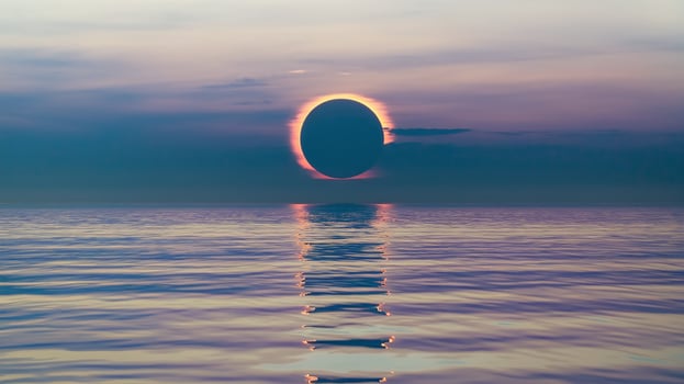 Solar Eclipse Over Calm Ocean Reflecting Vibrant Twilight Colors in Serene Sky at Sunrise or Sunset photo