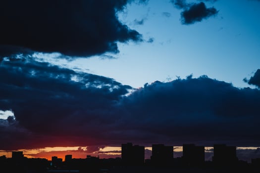 City skyline silhouetted against cloudy sky at sunset photo