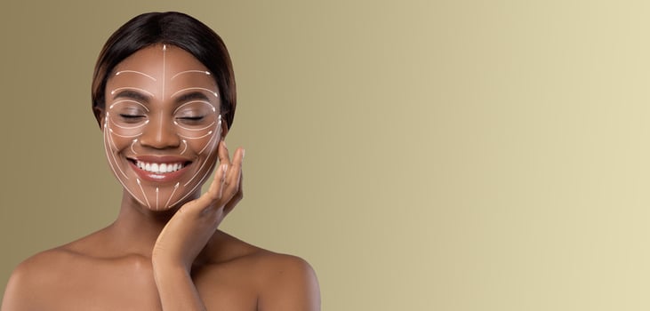 African American lady is relaxing and pampering herself with a skincare routine. She smiles while applying a beauty treatment, surrounded by a soothing, isolated environment photo