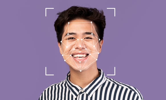 A young person is smiling against a solid purple background. photo