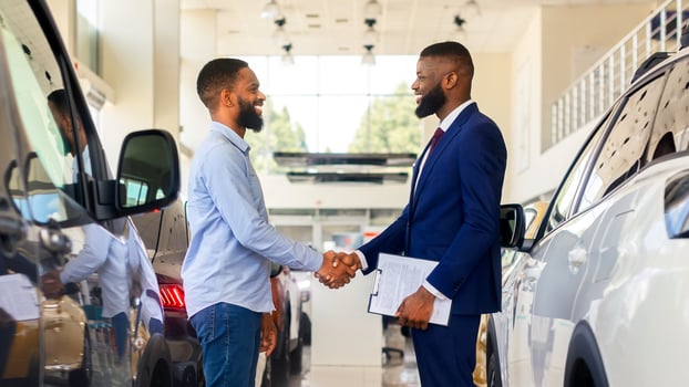 Black Car Seller Shaking Hands With Customer In Modern Dealership Center, Salesman Handshaking With Client After Successful Deal, Selling New Auto To African American Man In Automobile Showroom photo