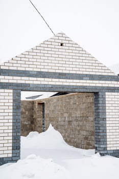 A sturdy brick building stands tall in winter, its roof blanketed in glistening snow, creating a picturesque scene that showcases the charm and tranquility of the season photo
